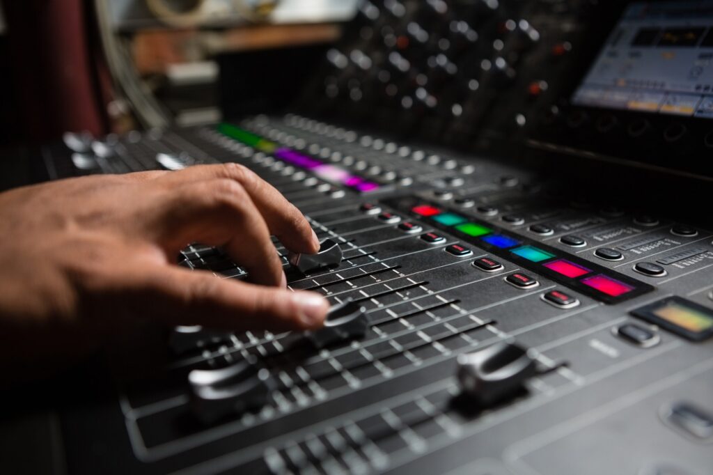 Hand of male audio engineer using sound mixer